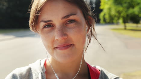 Pretty-woman-portrait-smiling-wearing-headphones-outdoors